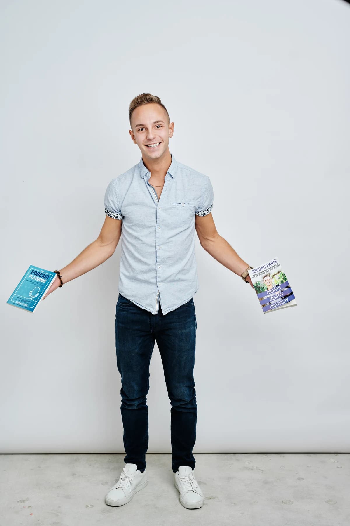 Jordan smiling with a book in each hand.