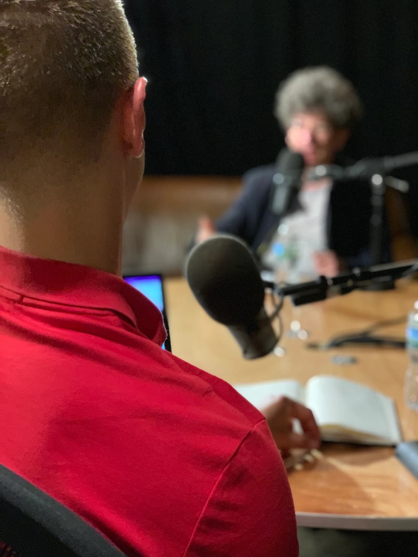The interview seen over Jordan's shoulder, with James across the table.