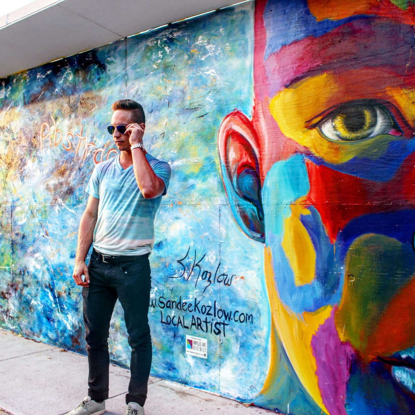 Jordan standing in front of a colorful mural in Naples.