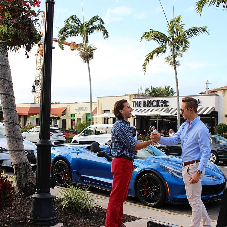 Jordan and Patrick shaking hands on a palm-lined street in Naples.