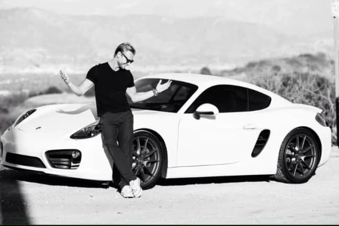 Steve beside his white Porsche, in black and white.