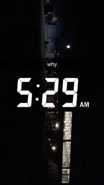 The lit football facility before sunrise, with "5:29 AM" and "why" on the photograph.