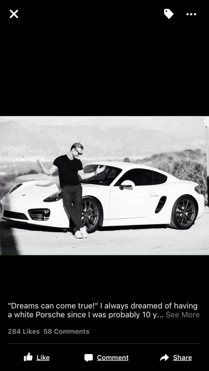 Steve standing beside a white Porsche in a black and white photograph.